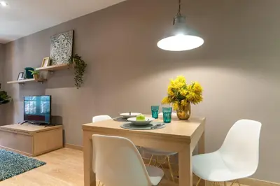 a dining room with a table and white chairs at Casa PILAR Central By MyRentalHost in Barcelona