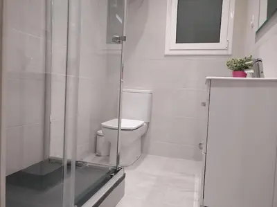a bathroom with a toilet and a glass shower at Sagrada Familia ART Apt By MyRentalHost in Barcelona