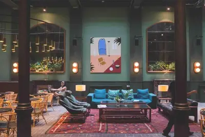 a lobby with blue furniture and a person sitting on a couch at Sagrada Familia ART Apt By MyRentalHost in Barcelona