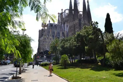 a person walking down a sidewalk in front of a building at Sagrada Familia ART Apt By MyRentalHost in Barcelona