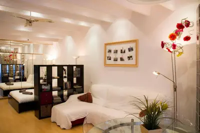 a living room with a white couch and a table at Studio Gracia By MyRentalHost in Barcelona