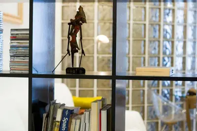 a book shelf with a figurine on top of books at Studio Gracia By MyRentalHost in Barcelona