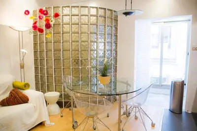 a glass table in a living room with a wall at Studio Gracia By MyRentalHost in Barcelona