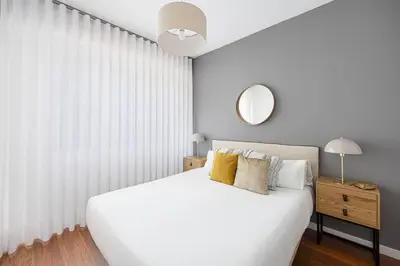 a bedroom with a white bed and a mirror at Live Like A Local In Bcn in Barcelona