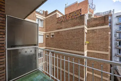 a balcony with a metal railing and a brick building at Live Like A Local In Bcn in Barcelona