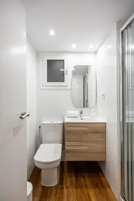 a white bathroom with a toilet and a mirror at Live Like A Local In Bcn in Barcelona