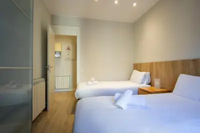 a hotel room with two beds and a bathroom at Housalia Sagrada Familia Views in Barcelona