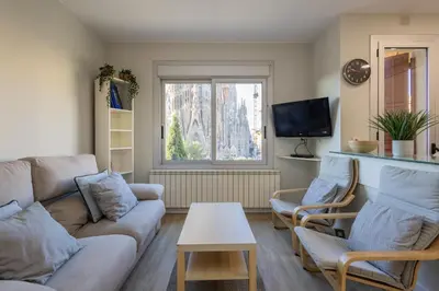 a living room with a couch and chairs and a tv at Housalia Sagrada Familia Views in Barcelona