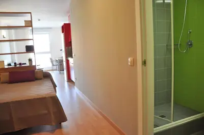 a living room with a bed and a shower at Alojamientos Universitarios Resa Hipatia in Terrassa