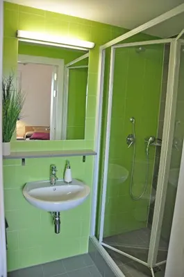 a green bathroom with a sink and a shower at Alojamientos Universitarios Resa Hipatia in Terrassa