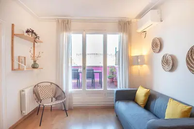 a living room with a blue couch and a window at Penthouse Apartment with Terrace in Barcelona City Center in Barcelona