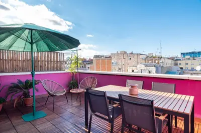 a table and chairs and an umbrella on a balcony at Penthouse Apartment with Terrace in Barcelona City Center in Barcelona