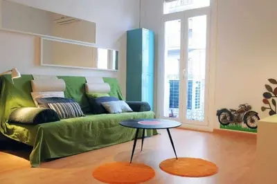 a living room with a green couch and a table at Calm Modern Apartment in Barcelona