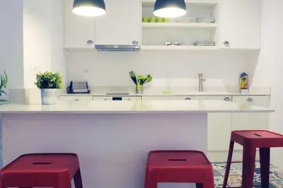 a kitchen with two red stools in front of a counter at Calm Modern Apartment in Barcelona