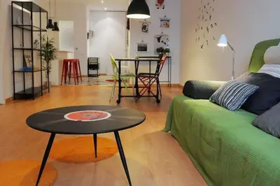 a living room with a green couch and a table at Calm Modern Apartment in Barcelona