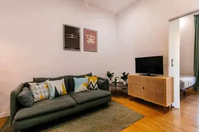 a living room with a couch and a flat screen tv at Cozy & Central Apartment in Barcelona