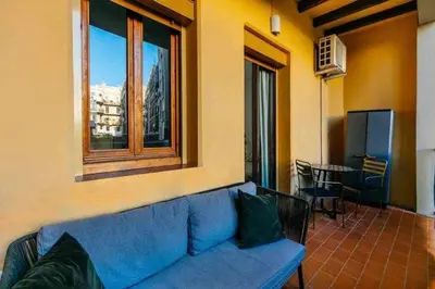 a blue couch in a room with a window at Cozy & Central Apartment in Barcelona
