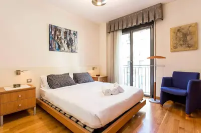a bedroom with a bed and a blue chair at Fabulous Flat By Paseo De Gracia in Barcelona