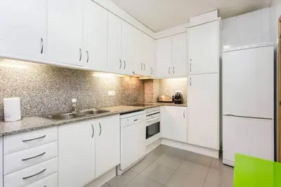 a white kitchen with white cabinets and a sink at Fabulous Flat By Paseo De Gracia in Barcelona
