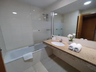 a bathroom with a sink and a shower and a mirror at Badalona Beach Apartment in Badalona