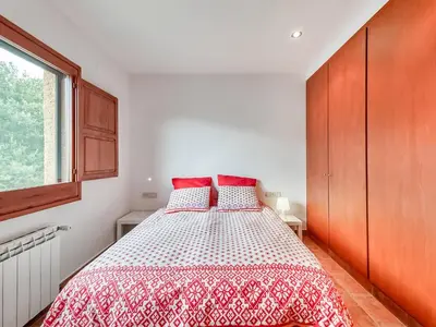 a bedroom with a bed with a red and white bedspread at Holiday Home Montseny with Pool in Montseny