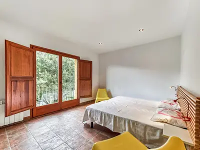 a bedroom with a bed and a window and chairs at Holiday Home Montseny with Pool in Montseny