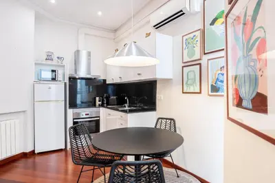 a kitchen with a table and chairs in a room at Modernist apartment in the best location, Eixample in Barcelona