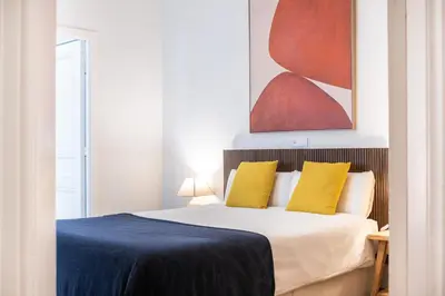 a bedroom with a bed with blue sheets and yellow pillows at Modernist apartment in the best location, Eixample in Barcelona