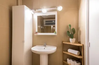 a small bathroom with a sink and a mirror at Comfortable Apartment for Groups next to Sagrada Familia, Barcelona in Barcelona
