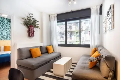 a living room with a couch and a window at Spacious & Comfortable Apartment in Barcelona City Center in Barcelona