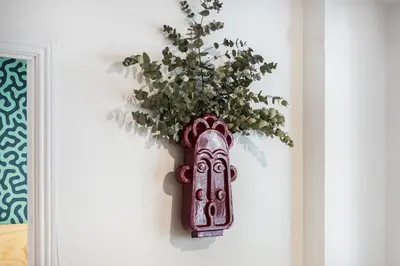 a vase with a plant in it on a wall at Spacious & Comfortable Apartment in Barcelona City Center in Barcelona