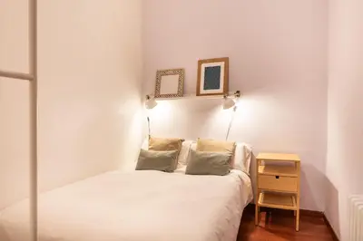 a small bedroom with a bed and a table at Spacious & Sunny Apartment with Terrace in the city center in Barcelona