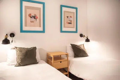 two beds sitting next to each other in a room at Spacious & Sunny Apartment with Terrace in the city center in Barcelona