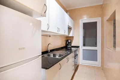 a kitchen with a sink and a refrigerator at Comfortable 3-Bedroom Apartment next to Sagrada Familia, Barcelona in Barcelona