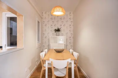 a dining room with a wooden table and white chairs at Comfortable 3-Bedroom Apartment next to Sagrada Familia, Barcelona in Barcelona