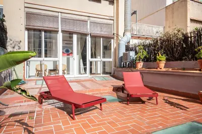 two red chairs sitting on a brick patio at Sunny Central Apartment with 100sqm Terrace in Barcelona in Barcelona