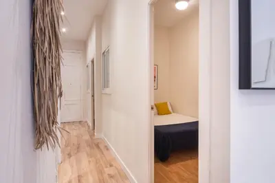 a hallway leading to a bedroom with a bed in a room at Sunny Central Apartment with 100sqm Terrace in Barcelona in Barcelona