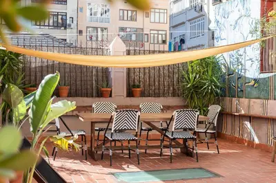 a patio with a table and chairs and a hammock at Sunny Central Apartment with 100sqm Terrace in Barcelona in Barcelona