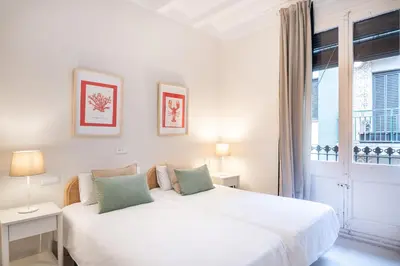 a white bedroom with a bed and a window at Cozy Apartment in the Heart of Gracia, Barcelona in Barcelona
