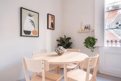 a white dining room with a table and chairs at Cozy Apartment with Terrace in Gracia, Barcelona Local Life in Barcelona