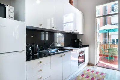 a kitchen with white cabinets and a sink at Oasis with a terrace in the heart of Gracia, Barcelona in Barcelona