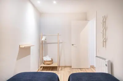 a white room with two beds and a door at Oasis with a terrace in the heart of Gracia, Barcelona in Barcelona