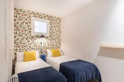 two beds in a small room with a wall at Oasis with a terrace in the heart of Gracia, Barcelona in Barcelona