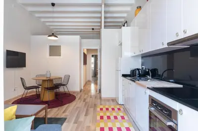 a kitchen with white cabinets and a table with chairs at Oasis with a terrace in the heart of Gracia, Barcelona in Barcelona