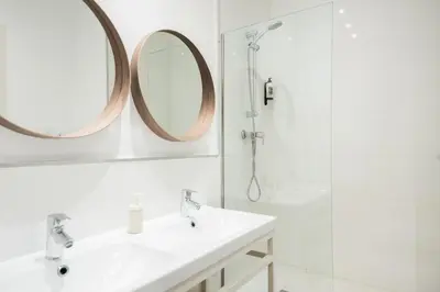 a bathroom with two sinks and a shower and a mirror at Sunny Terrace Apartment in Gracia, Barcelona - Local Lifestyle in Barcelona