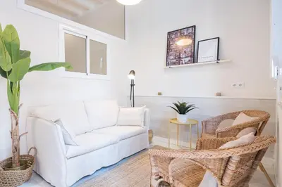 a living room with a white couch and rattan chairs at Sunny Terrace Apartment in Gracia, Barcelona - Local Lifestyle in Barcelona