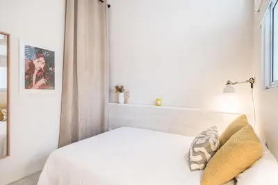 a bedroom with a white bed and a window at Sunny Apartment with Private Terrace in Gracia, Barcelona in Barcelona