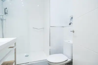 a white bathroom with a toilet and a shower at Sunny Apartment with Private Terrace in Gracia, Barcelona in Barcelona