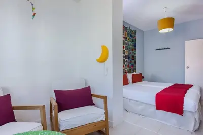a white bedroom with two beds and a chair at Charming 3 Bdr-2 Bthr In Gracia in Barcelona