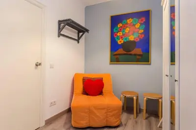 an orange chair with a red pillow in a room at Charming 3 Bdr-2 Bthr In Gracia in Barcelona